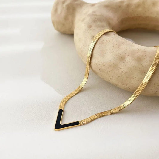 K Y R A gold herringbone chain necklace with black V pendant and enamel inlay